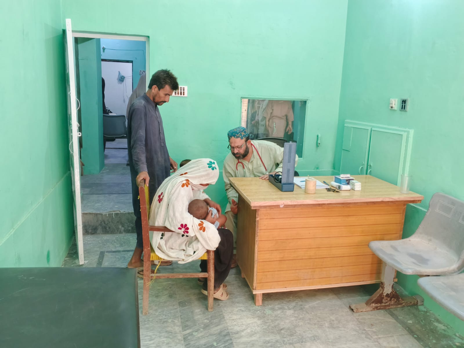 Doctor examining a child with family at Bukhari Clinic